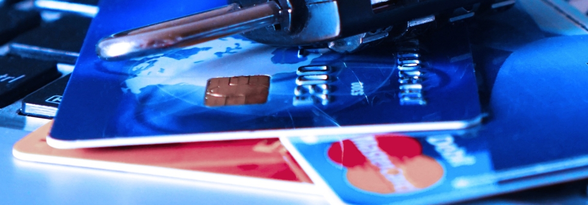 Eine Nahaufnahme eines Kombinationsvorhängeschlosses, das über einer Laptop-Tastatur auf Kreditkarten liegt. Es symbolisiert die Online-Sicherheit und den Schutz von Finanzinformationen inmitten von Bedenken wie gestohlenen Zugangsdaten oder einem PayPal-Datenleck.