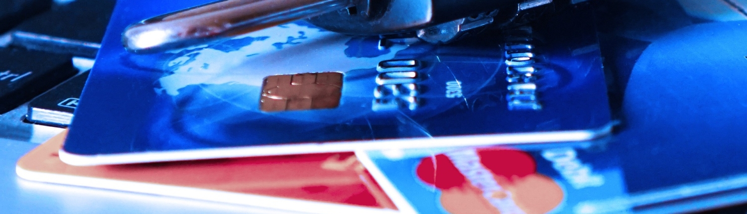 Eine Nahaufnahme eines Kombinationsvorhängeschlosses, das über einer Laptop-Tastatur auf Kreditkarten liegt. Es symbolisiert die Online-Sicherheit und den Schutz von Finanzinformationen inmitten von Bedenken wie gestohlenen Zugangsdaten oder einem PayPal-Datenleck.