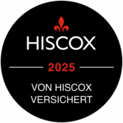 HISCOX Schwarzes kreisförmiges Abzeichen mit einer roten Lilienblüte über dem weißen Text Hiscox. Darunter steht in roter Schrift 2025. Darunter steht in weißer Schrift Von Hiscox Versichert.